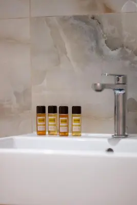 three bottles of essential oils sitting on top of a sink at Illyria Hotel in Ulcinj