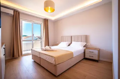 a bedroom with a bed and a large window at Illyria Hotel in Ulcinj