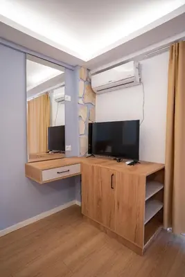 a room with a desk with a tv and a mirror at Illyria Hotel in Ulcinj