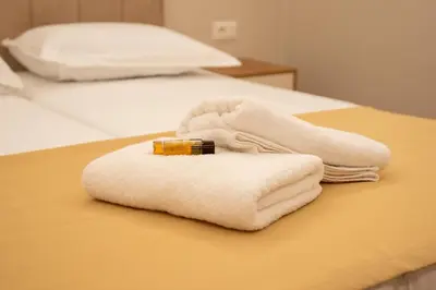 a white towel on a bed with a bottle on it at Illyria Hotel in Ulcinj