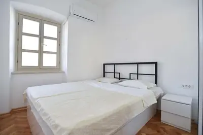 a white bedroom with a large bed and a window at PERFECT OLD TOWN SPOT in Budva in Budva