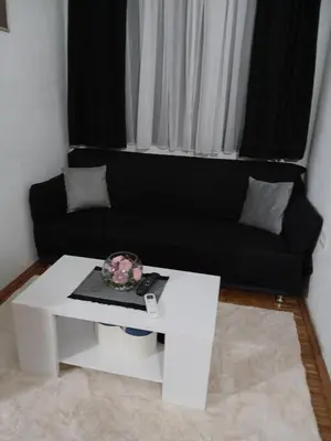 a living room with a black couch and a white coffee table at Dado in Virpazar