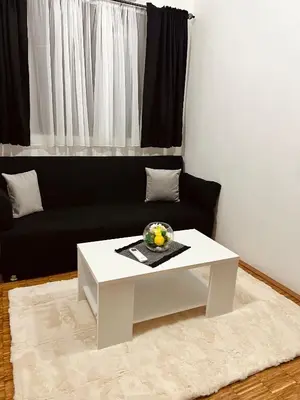 a living room with a white coffee table and a black couch at Dado in Virpazar