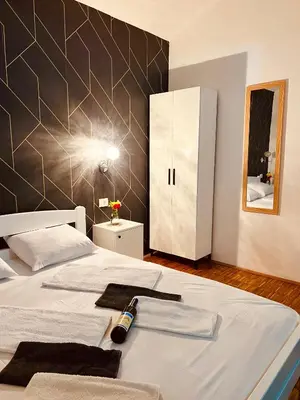 a bedroom with a bed with a bottle of wine on it at Dado in Virpazar