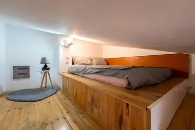 a bed on a wooden platform in a bedroom at Podgorica City Centre in Podgorica