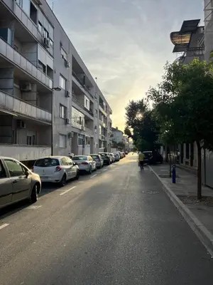 a street with cars parked on the side of a building at Podgorica City Centre in Podgorica
