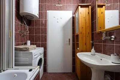 a bathroom with a sink and a washing machine at Podgorica City Centre in Podgorica