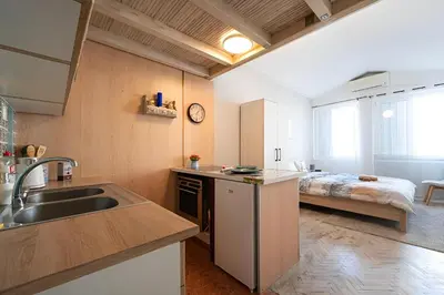 a kitchen with a sink and a bed in a room at Podgorica City Centre in Podgorica