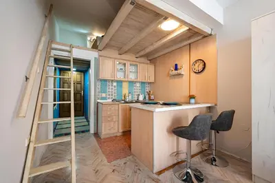 a kitchen with a ladder and some chairs in it at Podgorica City Centre in Podgorica