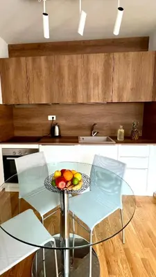 a kitchen with a glass table with a bowl of fruit on it at Four Views By The Sea Apartments in Budva