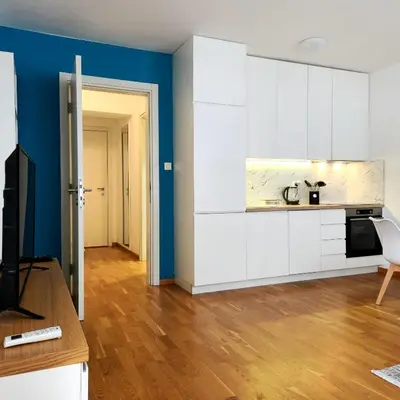 a kitchen with white cabinets and a blue wall at Four Views By The Sea Apartments in Budva