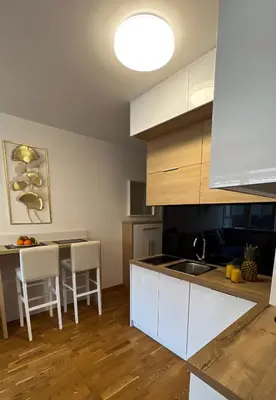 a kitchen with white cabinets and a table with chairs at Four Views By The Sea Apartments in Budva