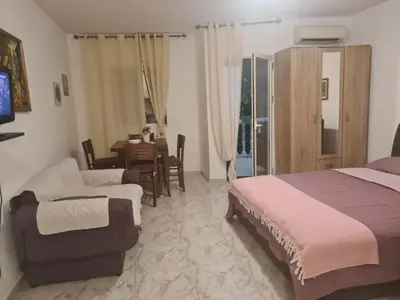 a bedroom with a bed and a couch and a table at Apartman Zvjezdana Dolina in Budva