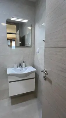 a bathroom with a sink and a mirror and a door at Kristina lux apartment in Bar