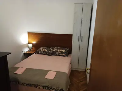 a small bedroom with a bed and a closet at Mira i Ola Apartman in Budva