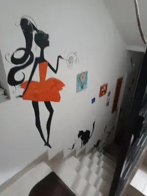 a wall with a painting of a woman on a staircase at Mira i Ola Apartman in Budva