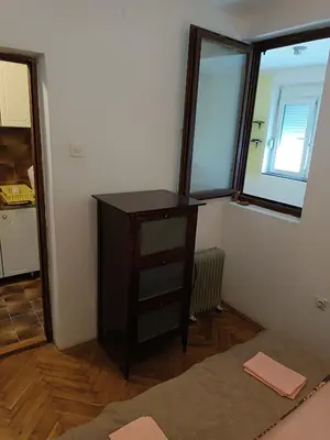 a room with a dresser and two windows at Mira i Ola Apartman in Budva
