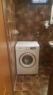 a bathroom with a washing machine in a stall at Mira i Ola Apartman in Budva