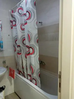 a shower curtain with red and white swirls in a bathroom at Renta Slatki kutak in Podgorica