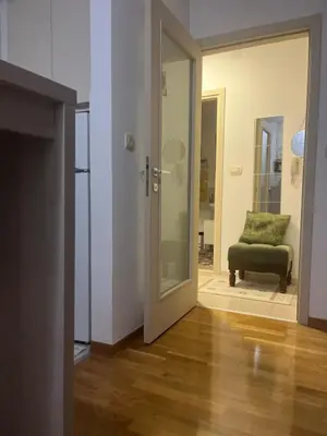 a living room with a green chair and a door at Renta Slatki kutak in Podgorica