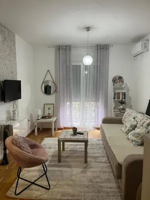 a living room with a couch and a table at Renta Slatki kutak in Podgorica