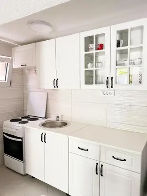 a kitchen with white cabinets and a sink at Zinzula 2 in Bar