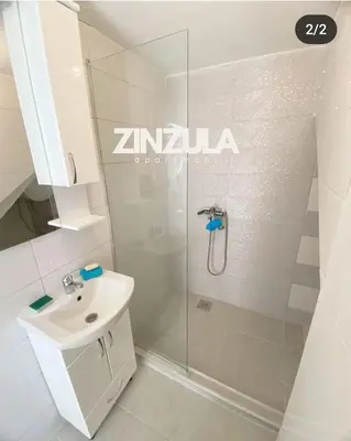 a white bathroom with a shower and a sink at Zinzula 2 in Bar