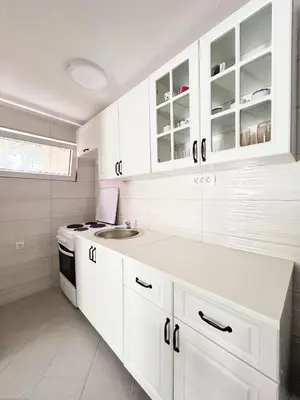 a white kitchen with white cabinets and a sink at Zinzula 2 in Bar