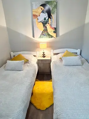 two beds in a room with a painting on the wall at My Choice in Budva