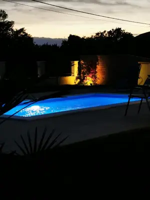 a swimming pool with blue lighting in a backyard at Visnjeva Gardens in Višnjevo