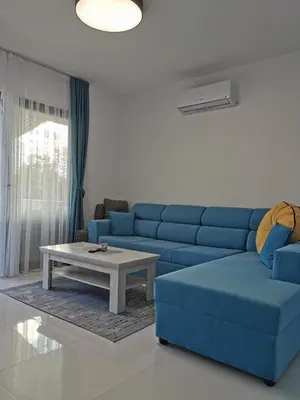 a living room with a blue couch and a coffee table at Visnjeva Gardens in Višnjevo