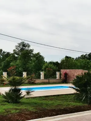 a swimming pool in the middle of a yard at Visnjeva Gardens in Višnjevo