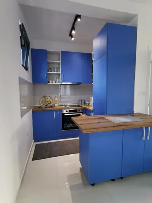a kitchen with blue cabinets and a wooden counter top at Visnjeva Gardens in Višnjevo