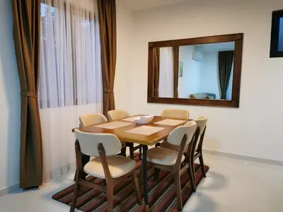 a dining room table with chairs and a mirror at Visnjeva Gardens in Višnjevo