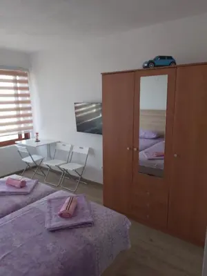a bedroom with two beds and a cabinet with a mirror at Apartmani Knezevic in Bar