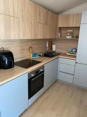 a kitchen with white cabinets and a black appliance at Apartmani Knezevic in Bar