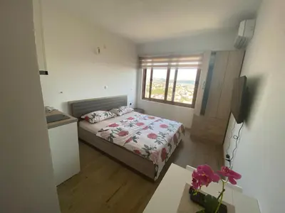 a small bedroom with a bed and a window at Apartmani Knezevic in Bar