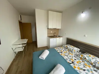 a small room with a bed and a kitchen at Apartmani Knezevic in Bar