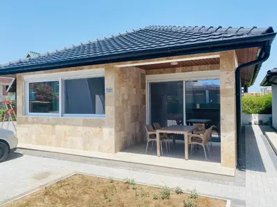 a pavilion with a table and chairs on a patio at Bungalow Cleo in Donji Štoj