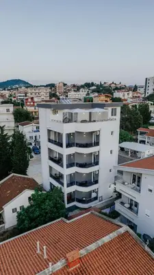 a white apartment building in the middle of a city at Lux DAM Apartments in Bar