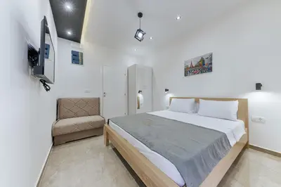 a bedroom with a large bed and a chair at Lux DAM Apartments in Bar