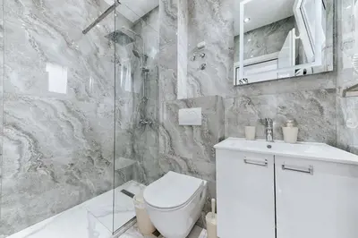 a bathroom with a toilet and a glass shower at Lux DAM Apartments in Bar