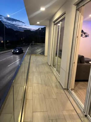 a balcony of a building with a car on the road at Maja Apartmani in Sutomore