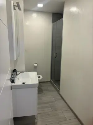 a white bathroom with a sink and a shower at Maja Apartmani in Sutomore