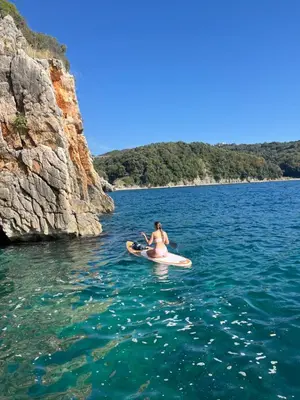 a woman sitting on a kayak in the water at Lavender Apartment - Close to the Beach - Private Garage Parking in Dobra Voda