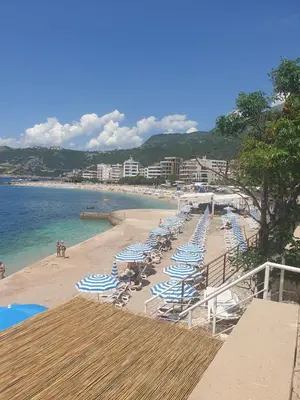 a beach with chairs and umbrellas and the ocean at Lavender Apartment - Close to the Beach - Private Garage Parking in Dobra Voda