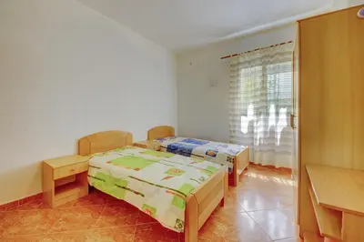 a bedroom with two beds and a window at Villa Blue Bay in Kruče