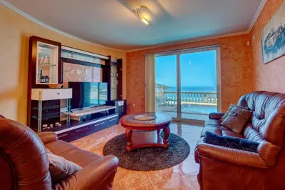 a living room with leather furniture and a large screen tv at Villa Blue Bay in Kruče