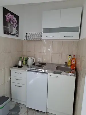 a small kitchen with white cabinets and a sink at Tinina Basta in Sutomore