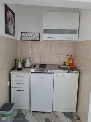 a small kitchen with white cabinets and a stove at Tinina Basta in Sutomore